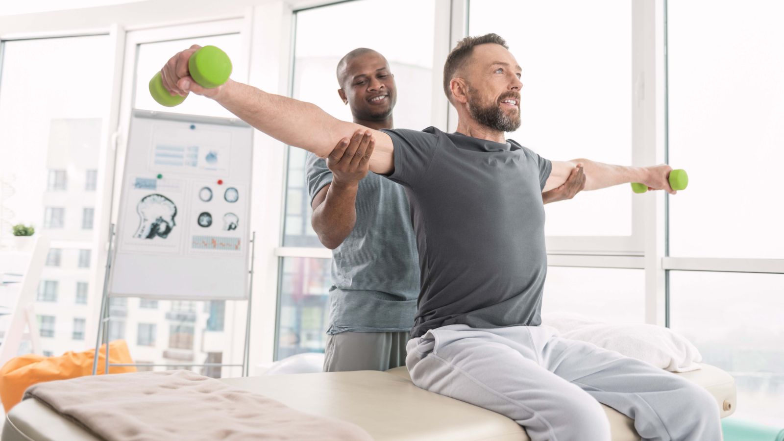 man rehabbing with dumbbells